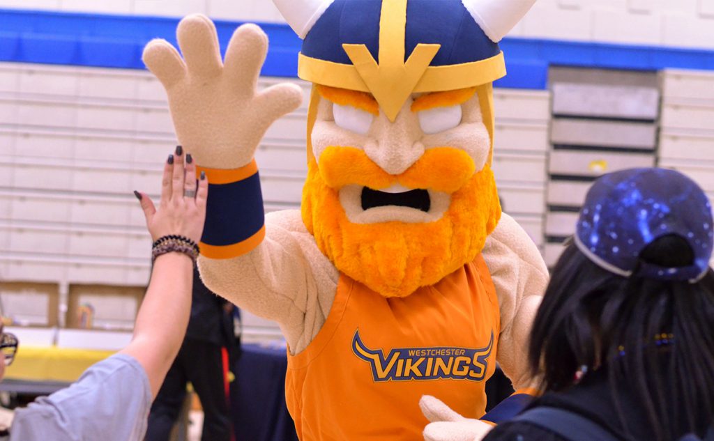 Chester the Viking high fives a student